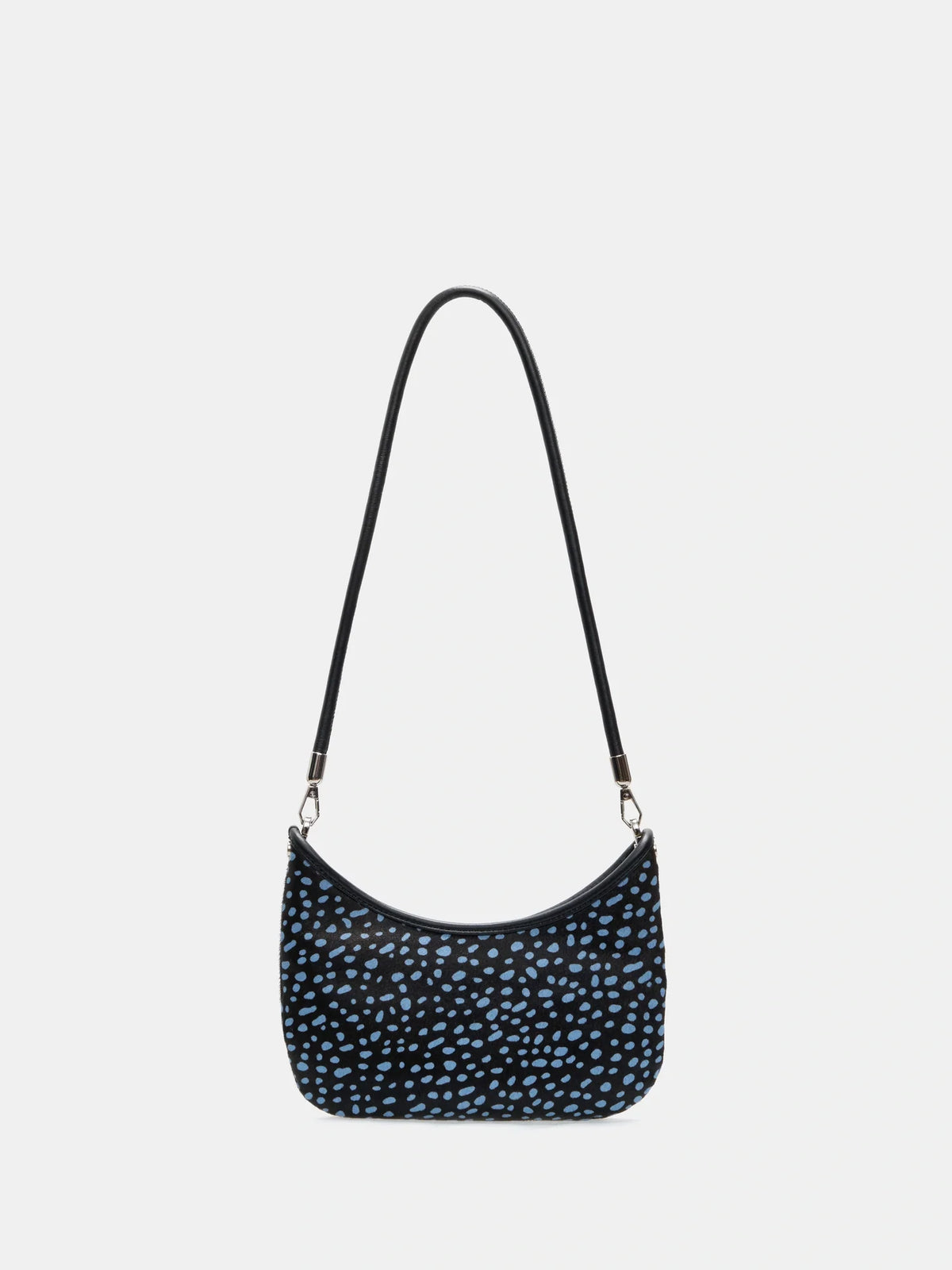Front view of a dark hair-on hide crescent bag with pale blue spots and a short black shoulder strap
