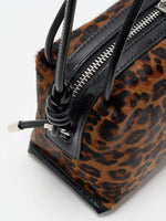 Close-up of knotted black cowhide strap attachment and zipper trim