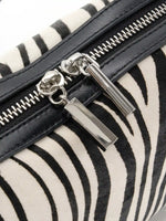 Close-up of silver-tone dual zipper pulls and black cowhide trim