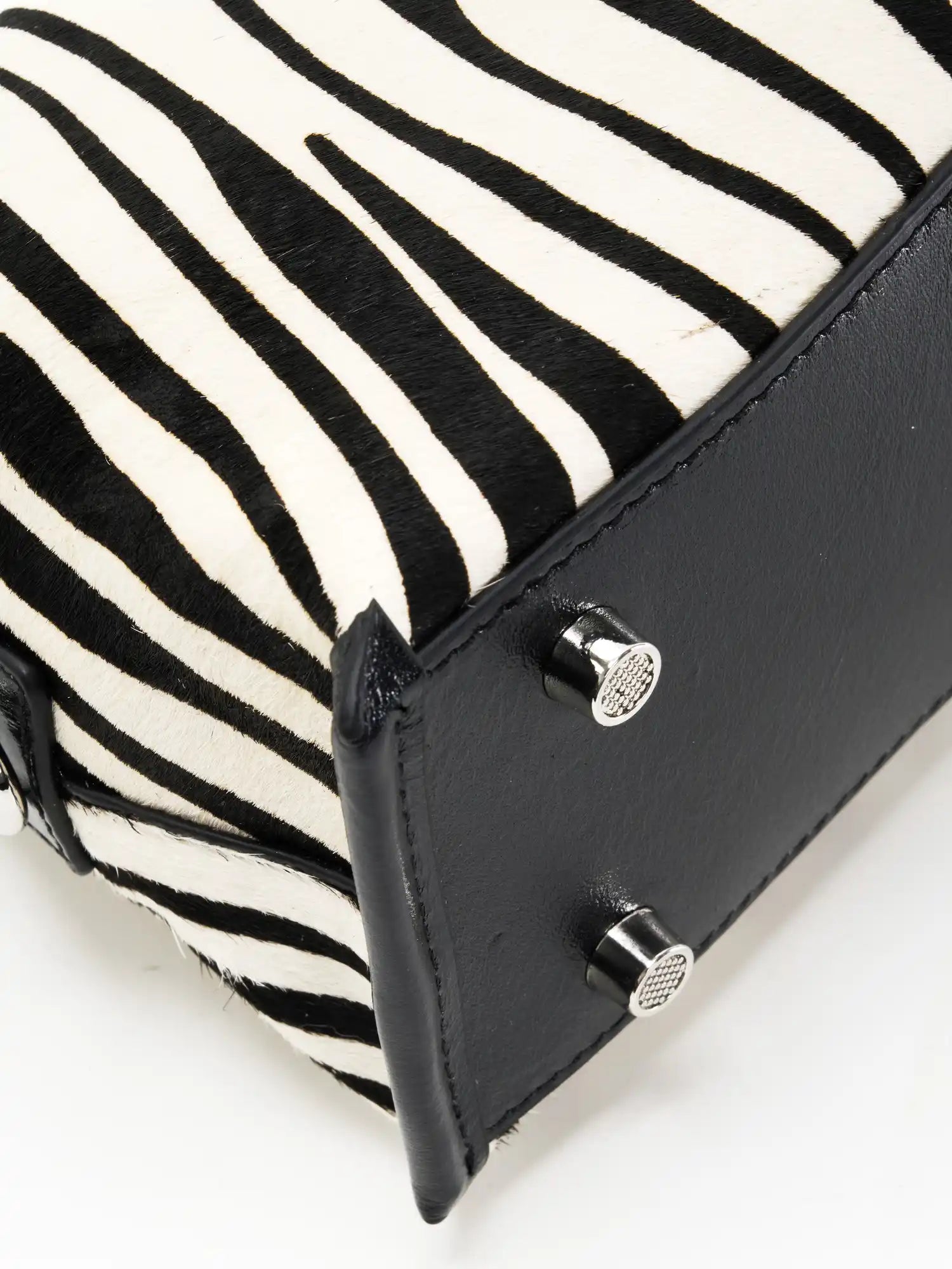 Close-up of black top-grain cowhide base and silver-tone feet