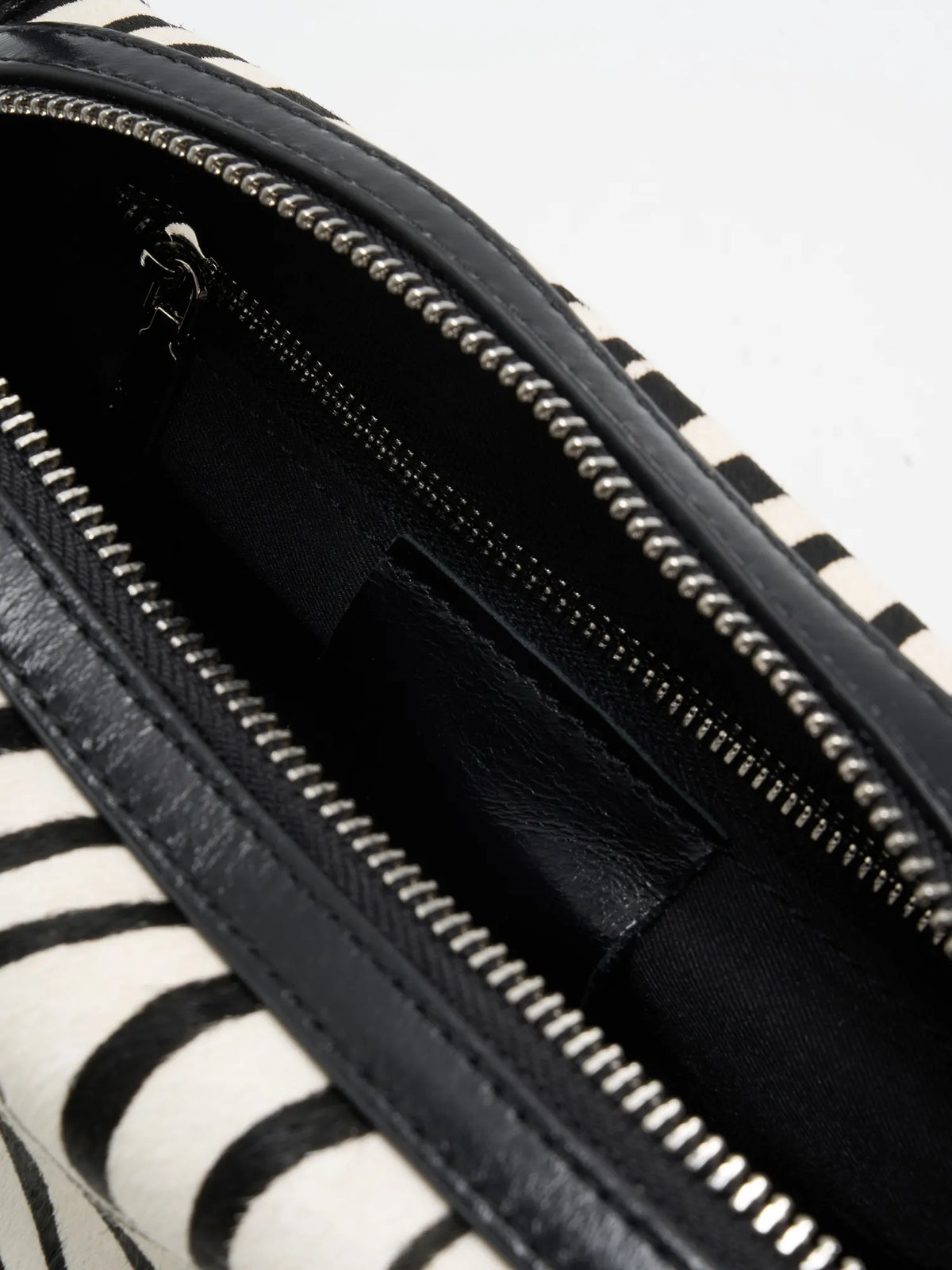 Close-up of black fabric interior with zip pocket and slip pocket