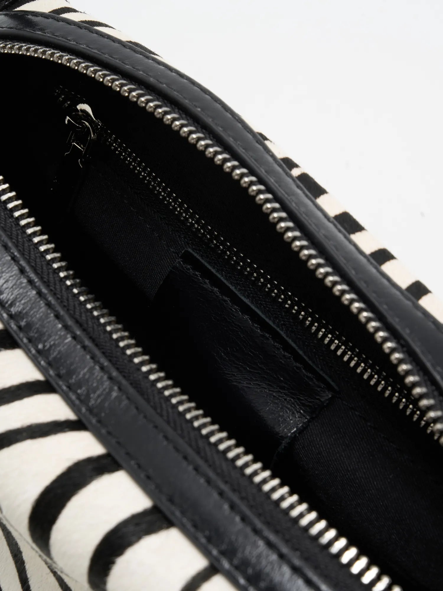 Close-up of black fabric interior with zip pocket and slip pocket