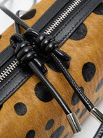 Close-up of knotted black top-grain cowhide crossbody strap detail
