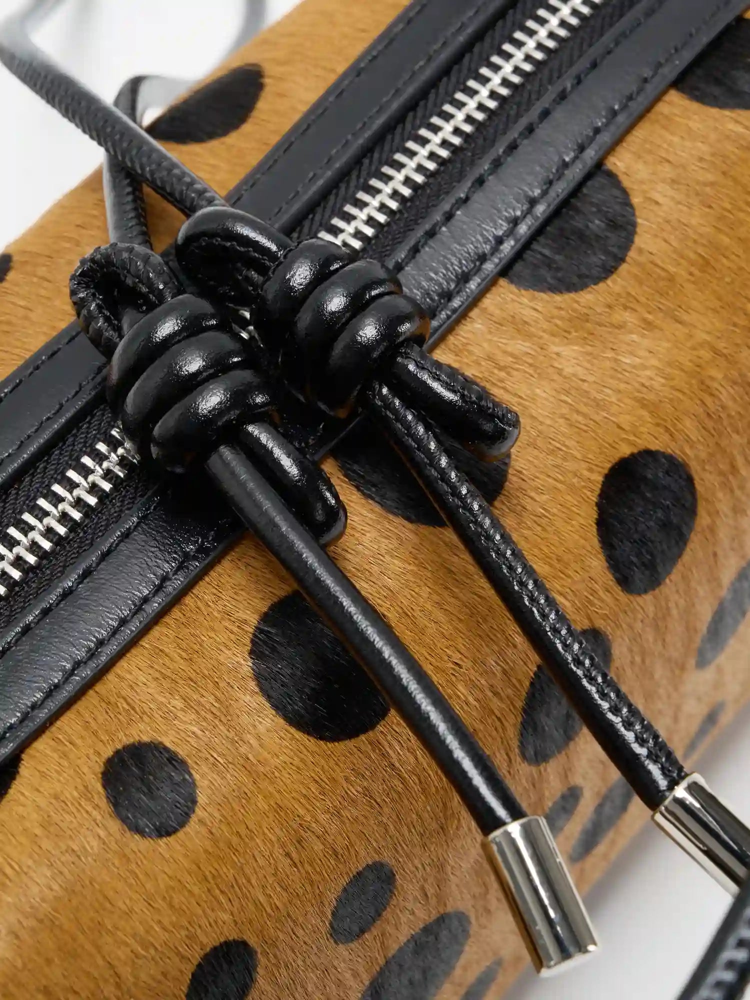 Close-up of knotted black top-grain cowhide crossbody strap detail