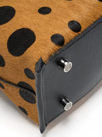 Close-up of black top-grain cowhide base and silver-tone feet