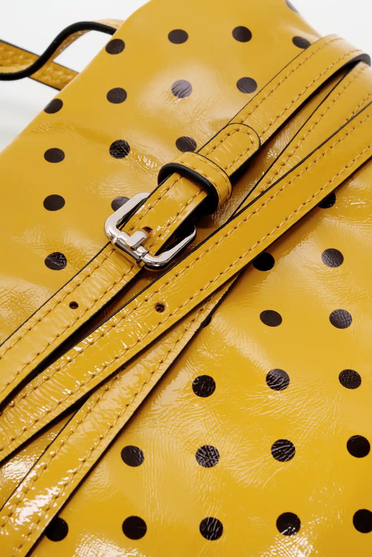 Adjustable yellow top-grain cowhide strap and silver-tone buckle close-up