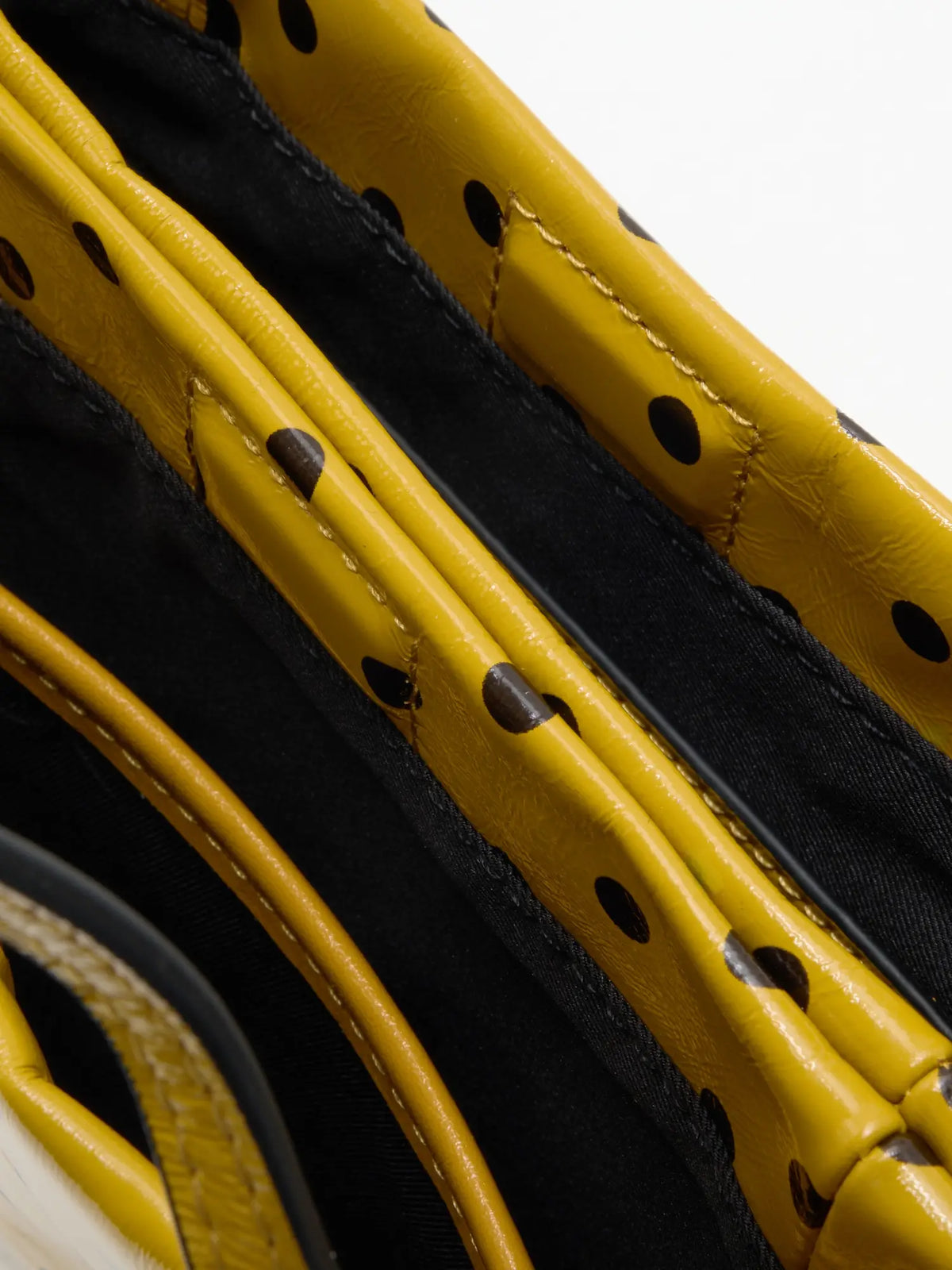 Two fabric-lined compartments inside the small yellow polka-dot bag