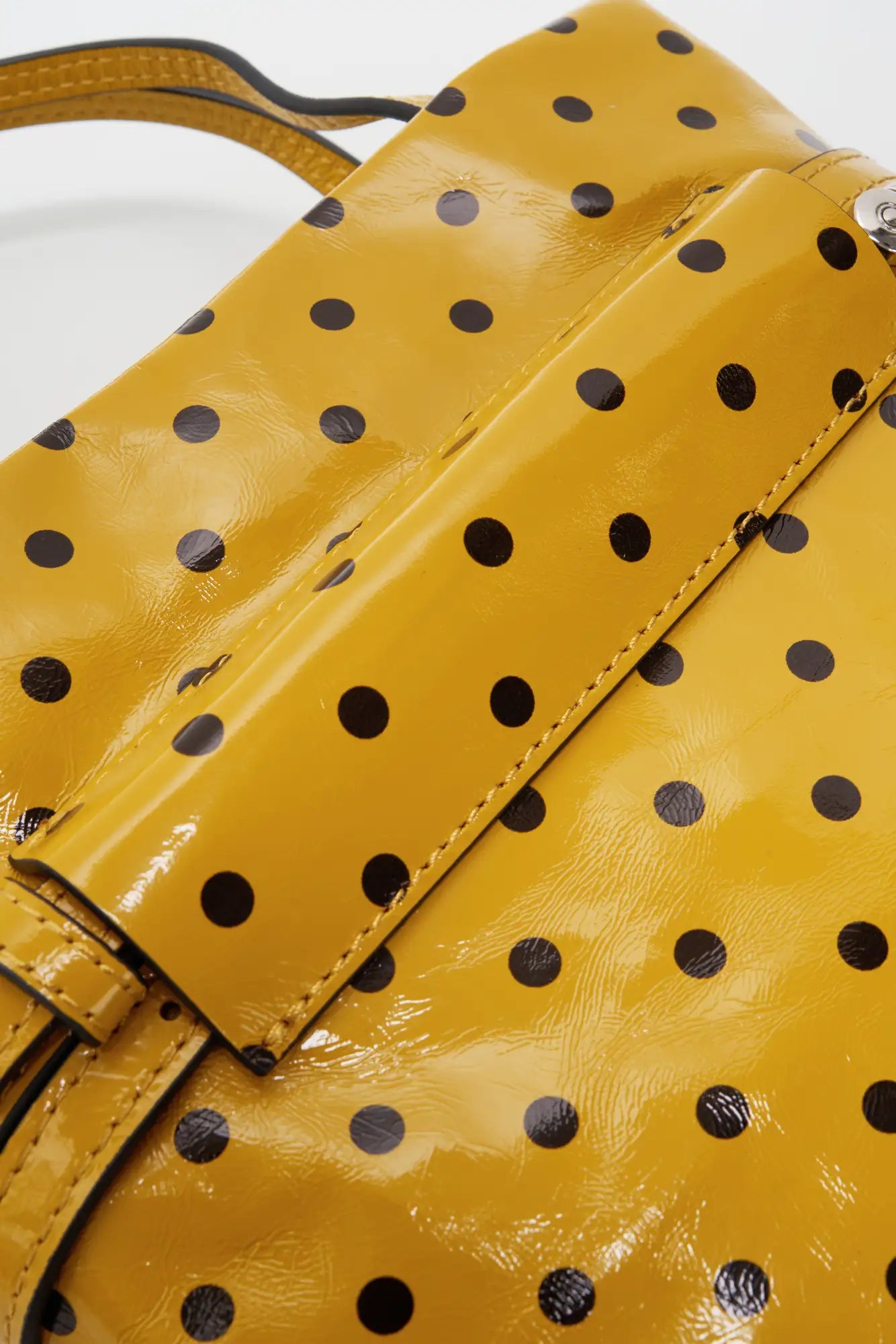 Wraparound strap keeper detail on the back of the yellow polka-dot bag