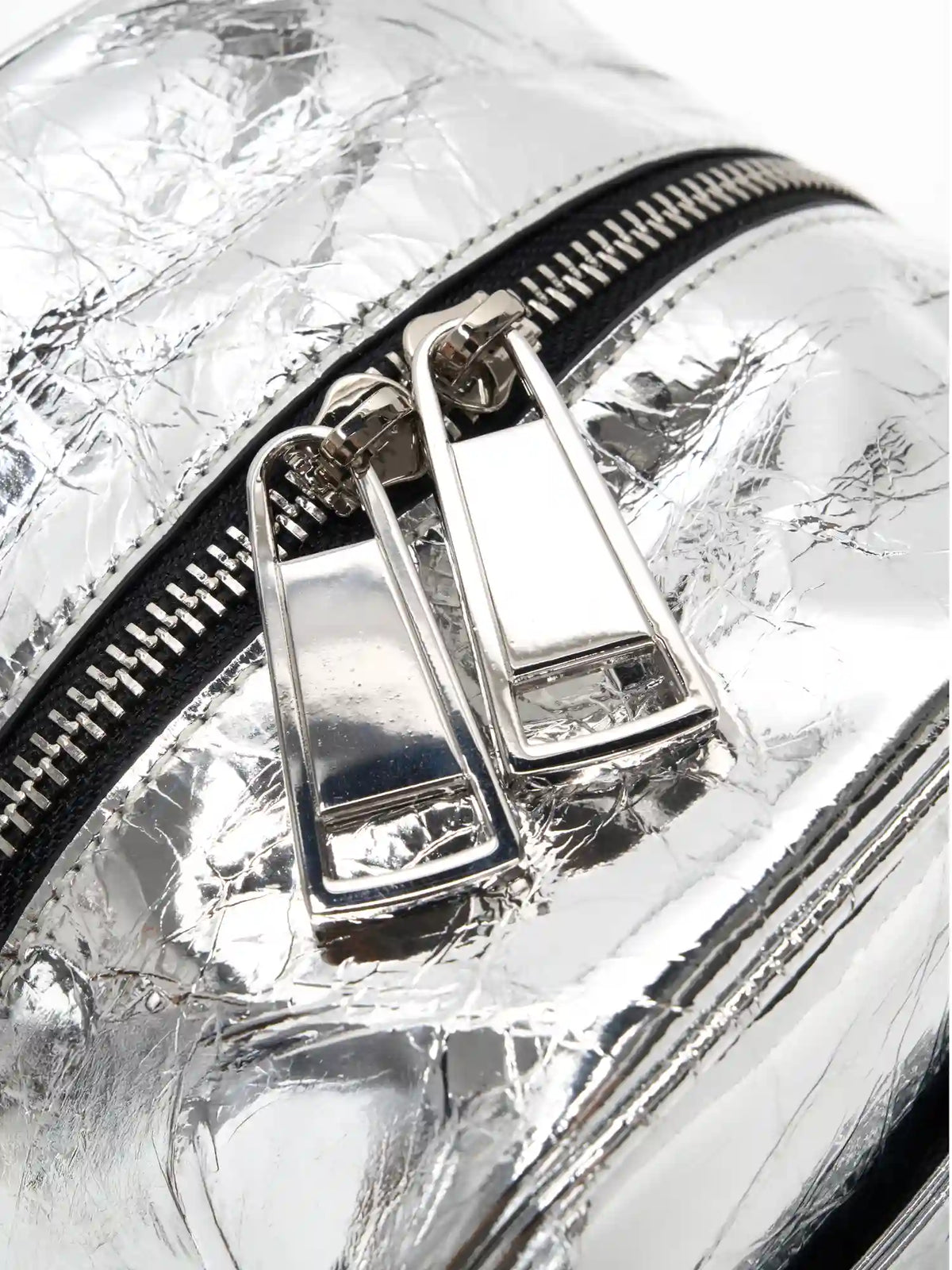 Dual silver-tone zipper pulls on the metallic cube bag close-up