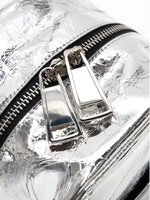 Dual silver-tone zipper pulls on the metallic cube bag close-up