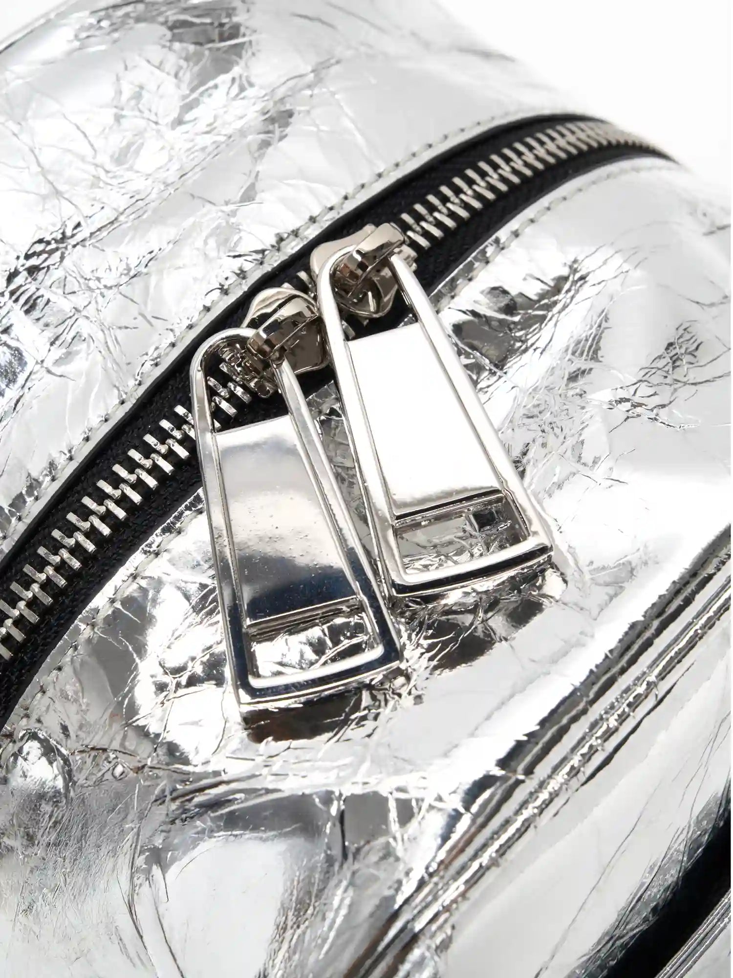 Dual silver-tone zipper pulls on the metallic cube bag close-up