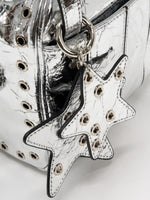 Layered metallic silver star charms with hollow grommets close-up