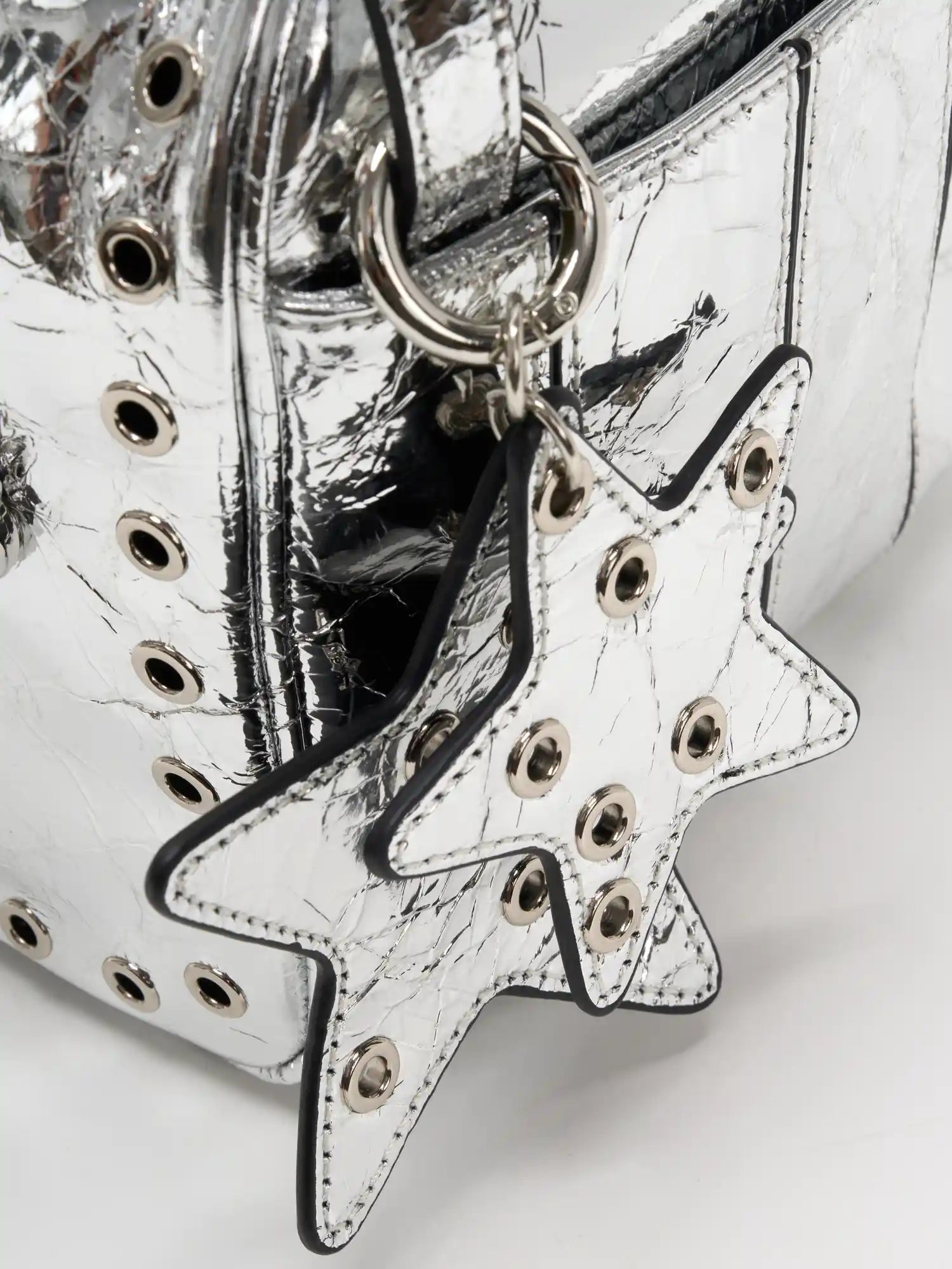 Layered metallic silver star charms with hollow grommets close-up