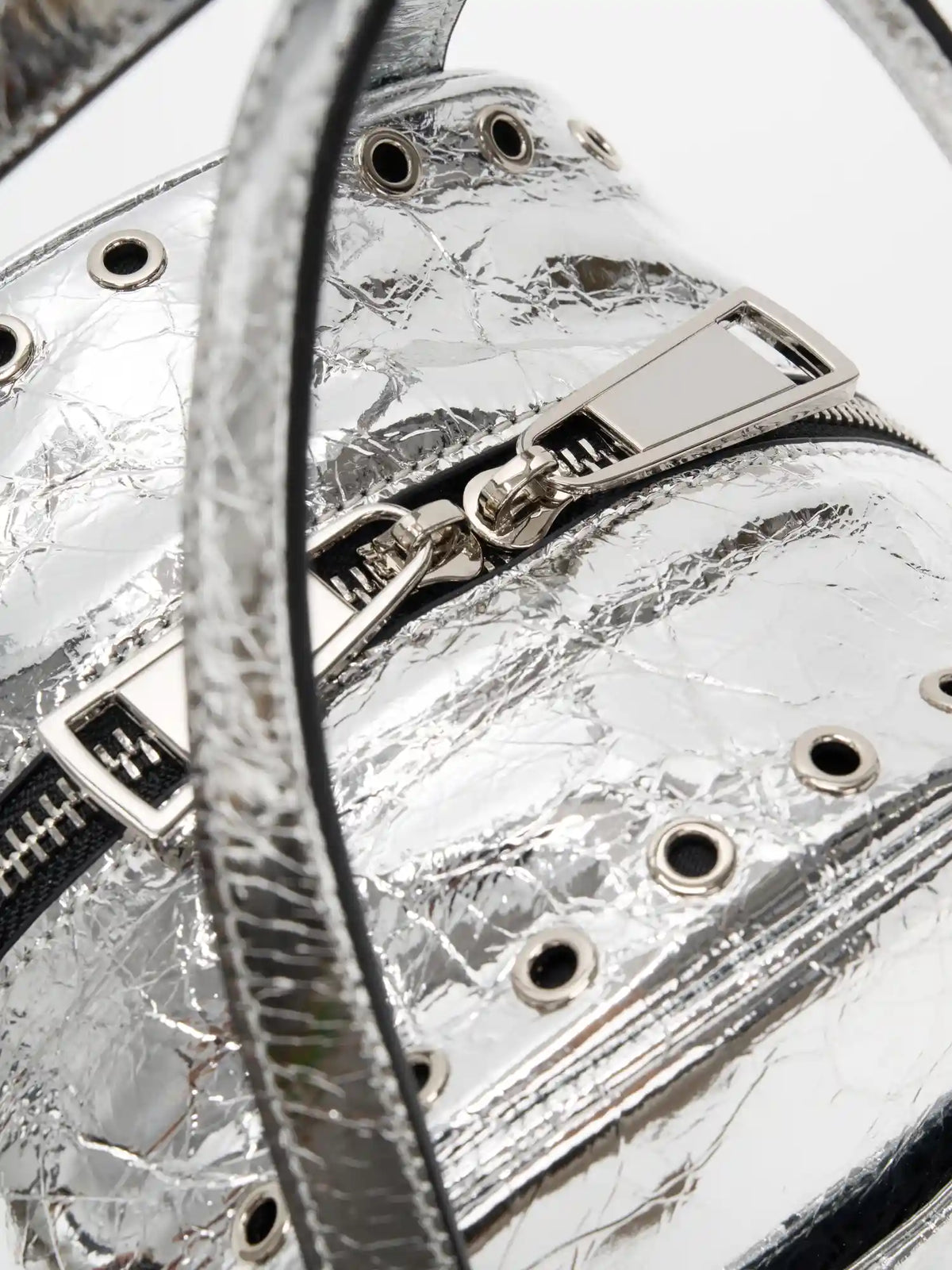 Top handle attachment and grommet-lined zip opening close-up