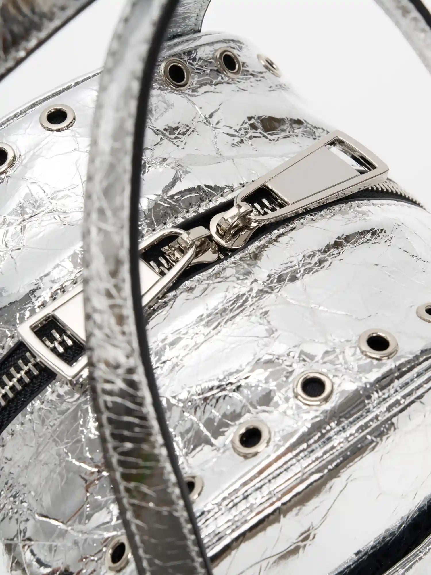Top handle attachment and grommet-lined zip opening close-up