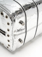Side and rear grommet trim on the metallic silver cube bag