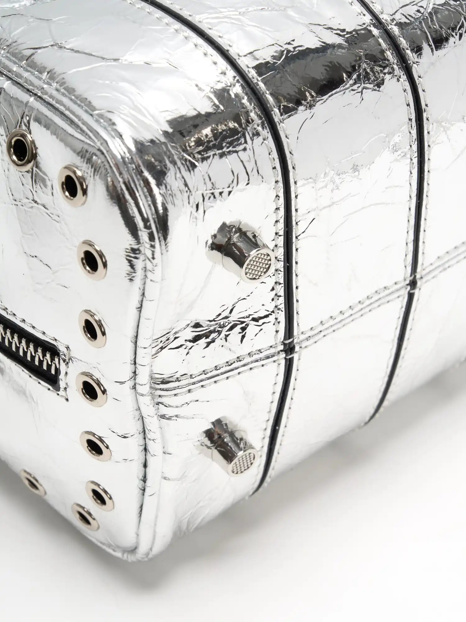 Side and rear grommet trim on the metallic silver cube bag