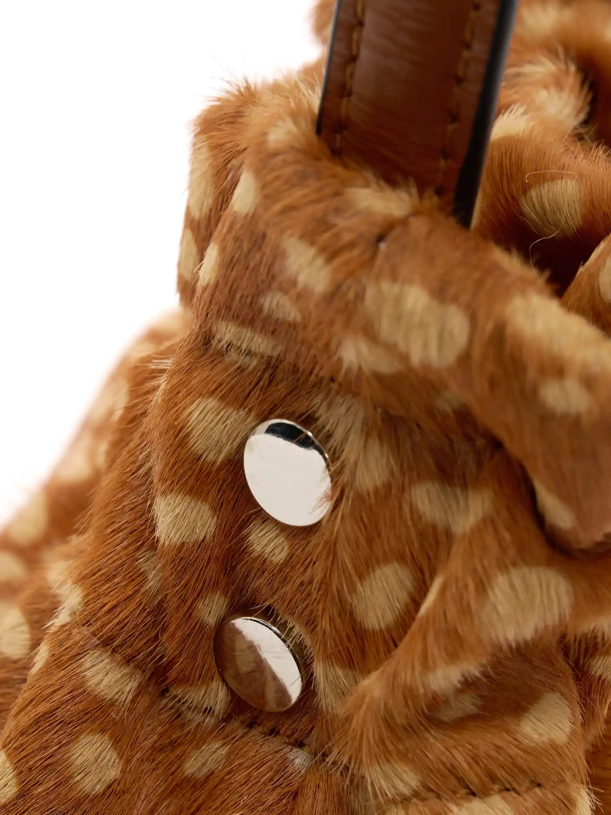 Silver-tone circular fittings beside the gathered top of the fawn-spotted bag
