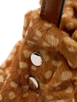 Silver-tone circular fittings beside the gathered top of the fawn-spotted bag