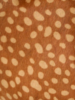 Close-up of pale fawn-inspired spots on warm brown hair-on hide
