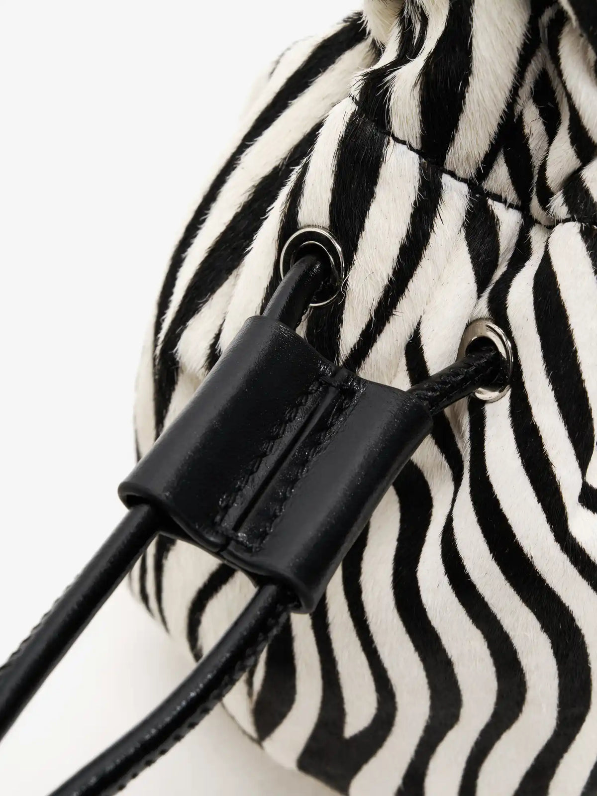 Black stitched drawstring keeper and silver-tone eyelets on the zebra-print bag