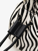 Black stitched drawstring keeper and silver-tone eyelets on the zebra-print bag