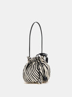 Angled view of zebra-print shoulder bag with gathered opening and black strap