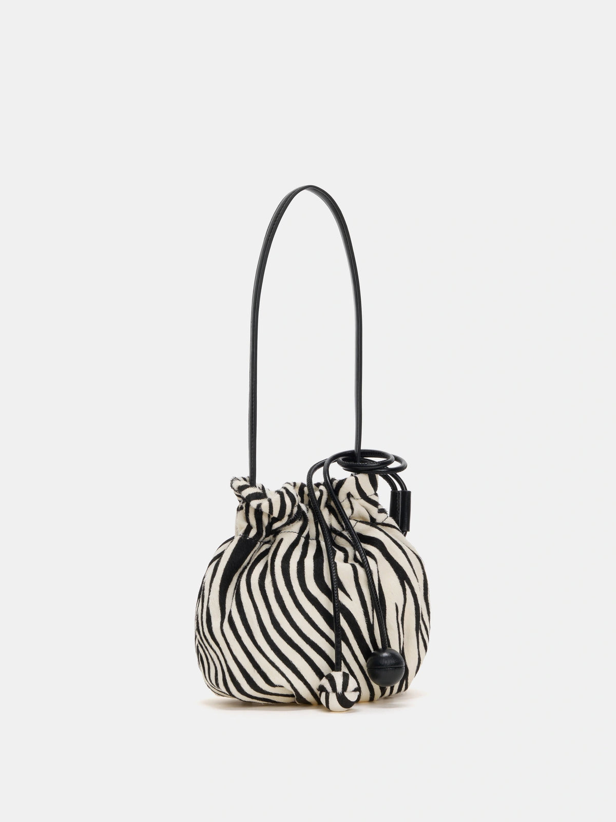 Angled view of zebra-print shoulder bag with gathered opening and black strap