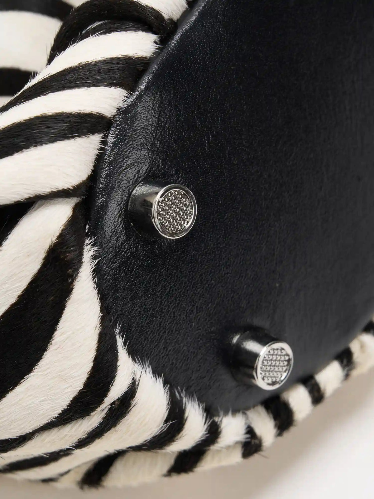 Black base panel and silver-tone metal feet on the zebra-print shoulder bag