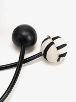 Smooth black sphere and matching zebra-print sphere on the drawstring ends