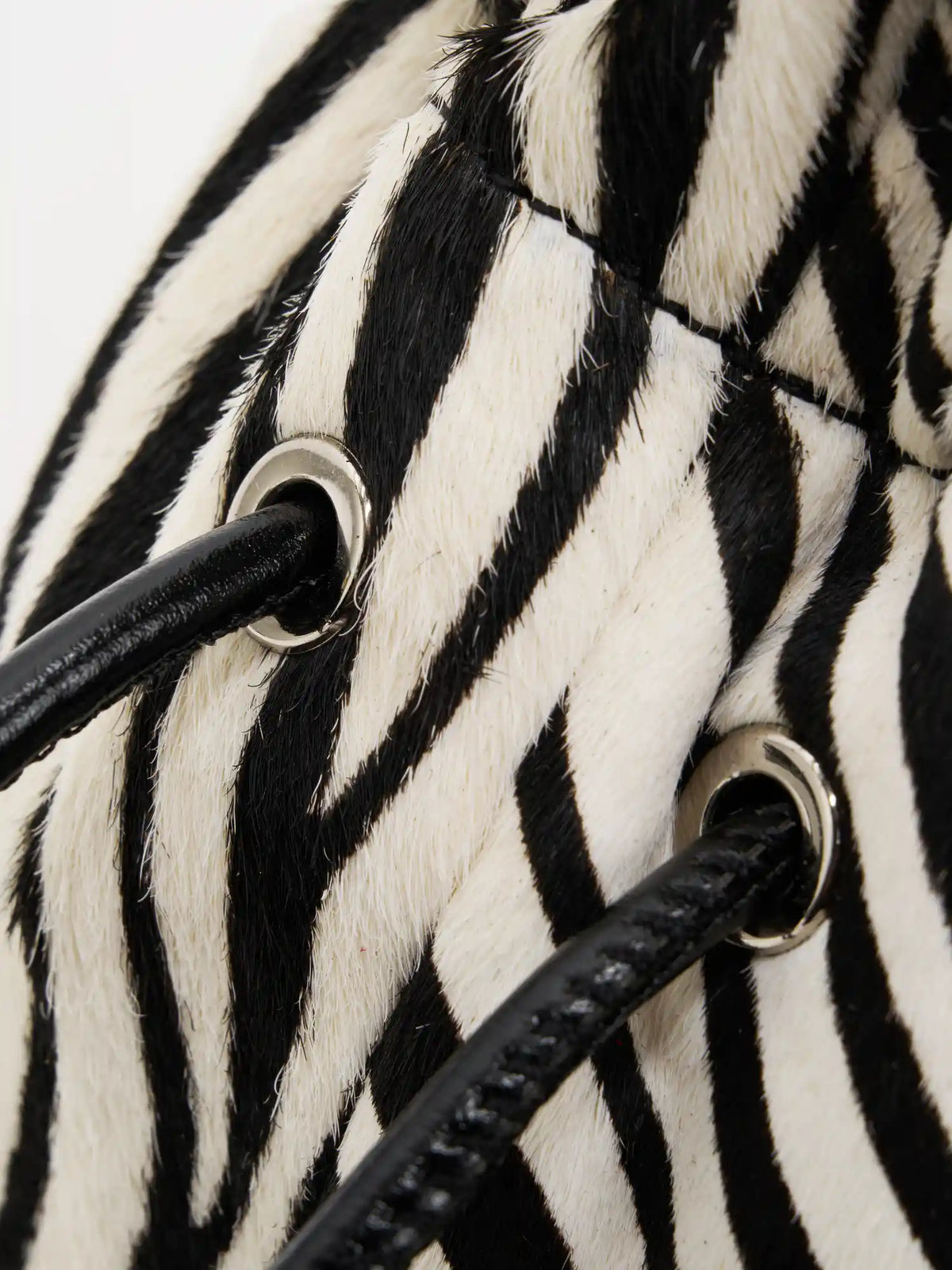 silver-tone eyelets detail of The Bobble Drawstring Shoulder Bag - Ivory Zebra