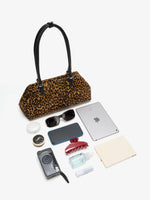 Leopard frame bag displayed with tablet phone sunglasses camera and daily essentials