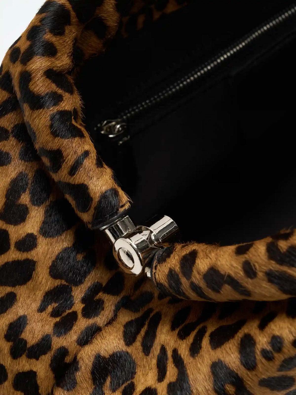 Leopard frame bag open to reveal black fabric-lined interior