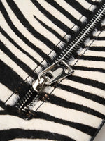 Metal-frame closure hardware on black and white zebra hair-on hide