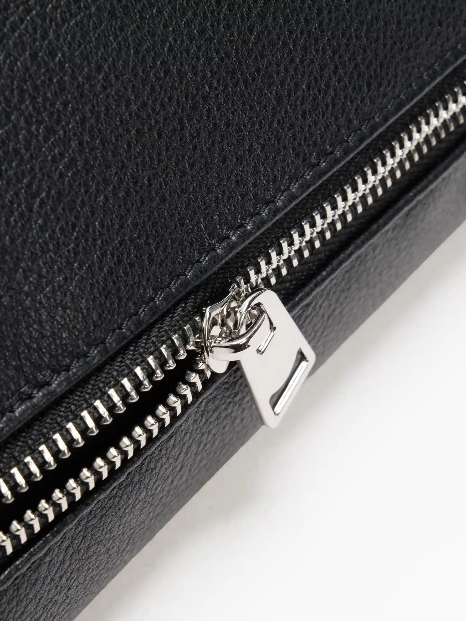 Silver-tone exterior zipper on fine-grain black leather close-up