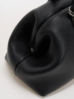 Sculpted side fold on the black fine-grain frame shoulder bag