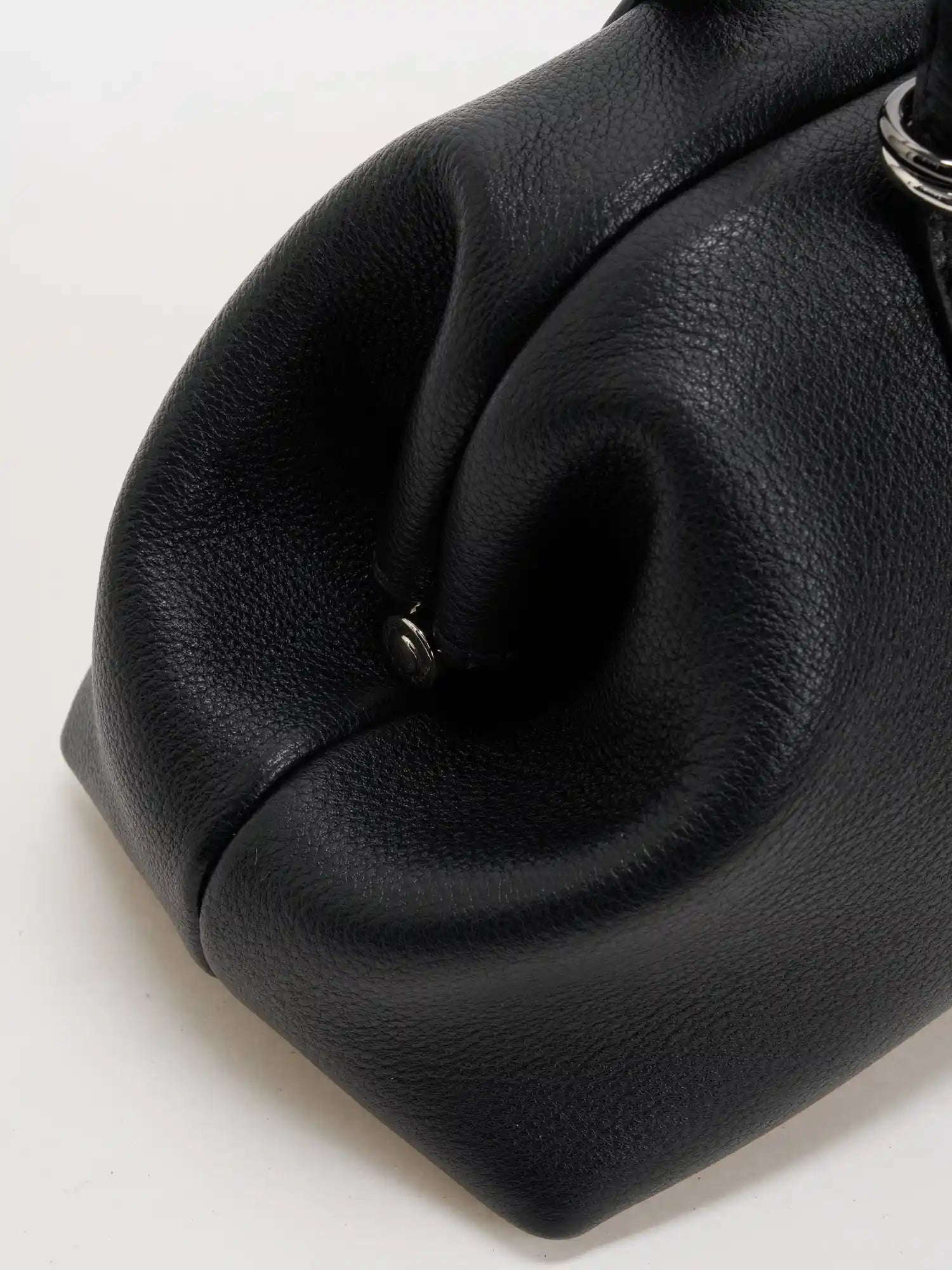 Sculpted side fold on the black fine-grain frame shoulder bag