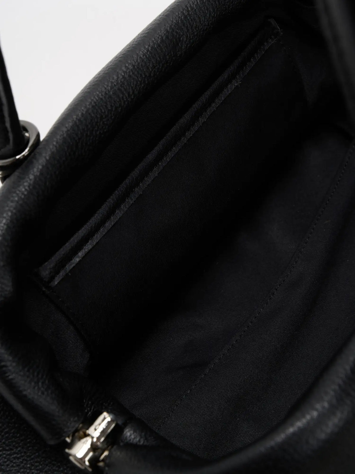 Black frame bag open to reveal roomy fabric-lined interior