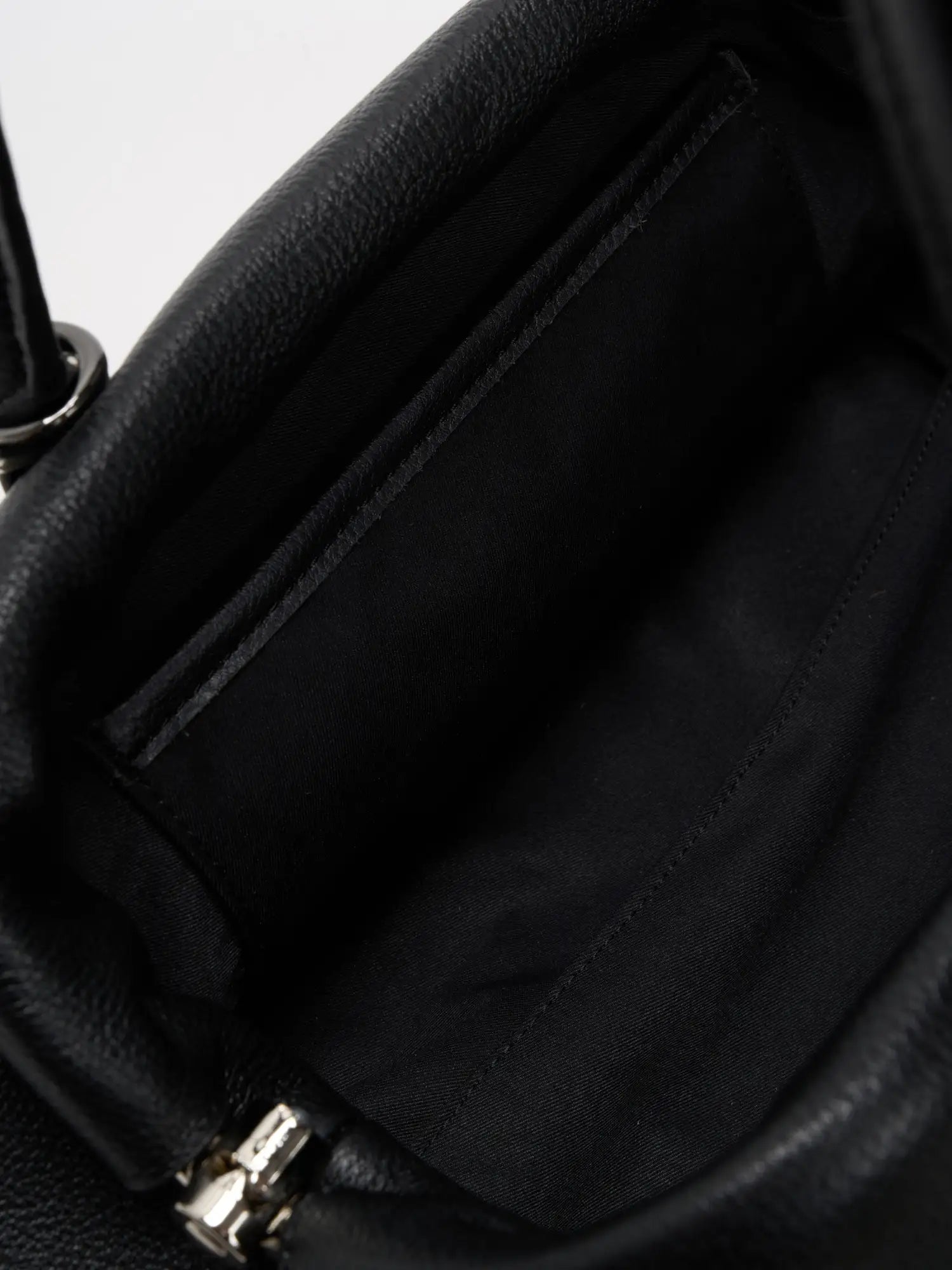 Black frame bag open to reveal roomy fabric-lined interior