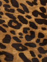 Close-up of warm brown and black leopard print on the hair-on hide surface