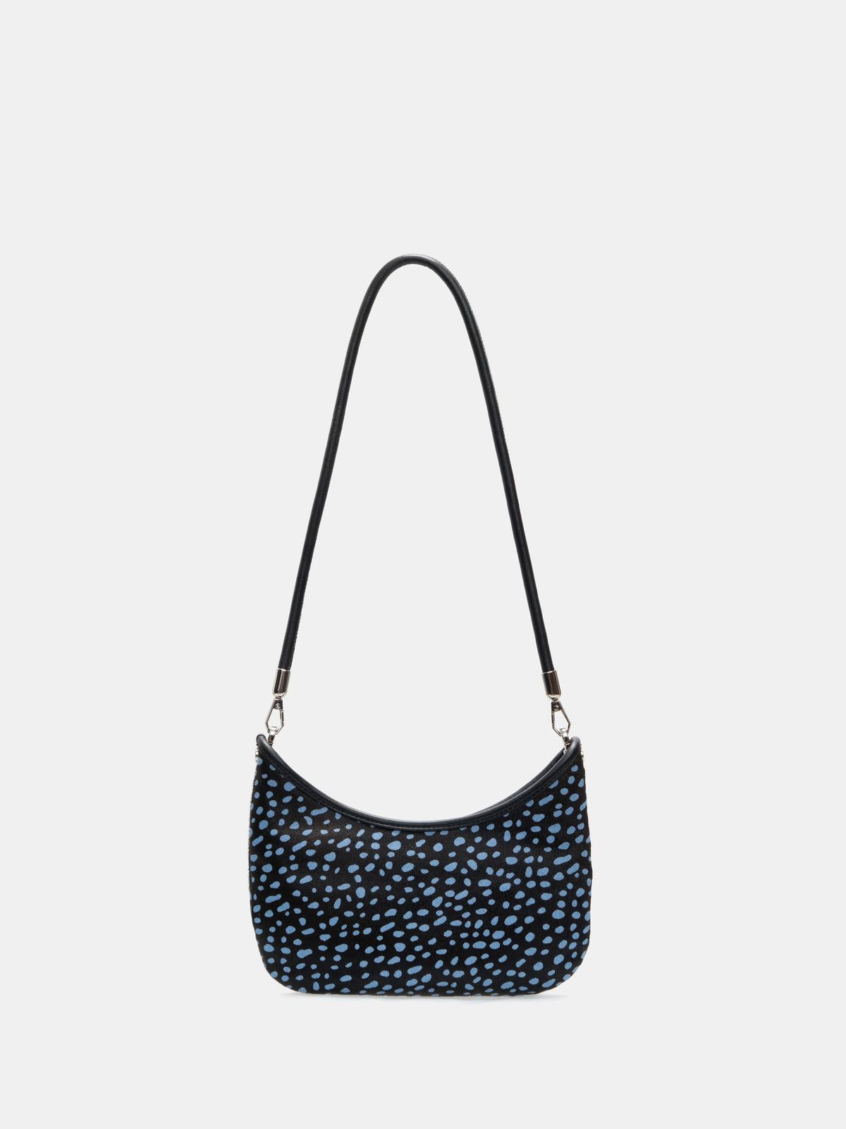 Front view of a dark hair-on hide crescent bag with pale blue spots and a short black shoulder strap