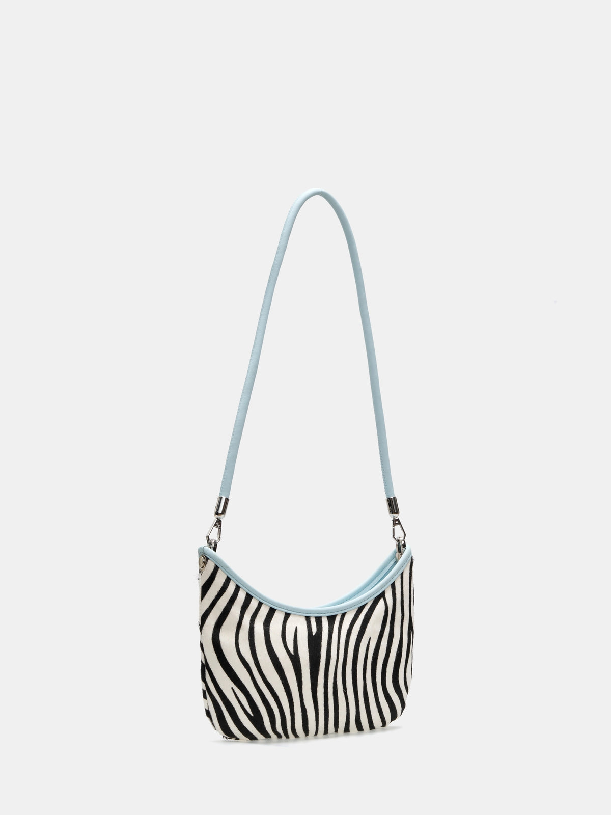 Angled view of an Ice Zebra crescent shoulder bag showing the curved opening and slim profile