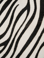 Close-up of black zebra stripes on the ivory hair-on hide surface