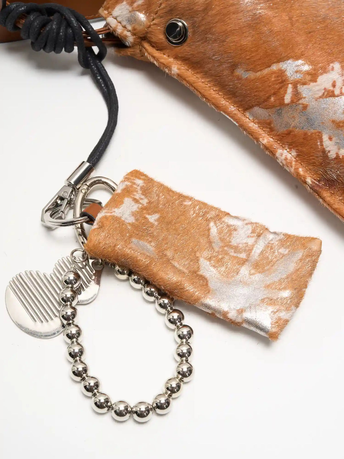 Reverse side of matching Gilded Caramel pouch with rings and silver-tone accessories