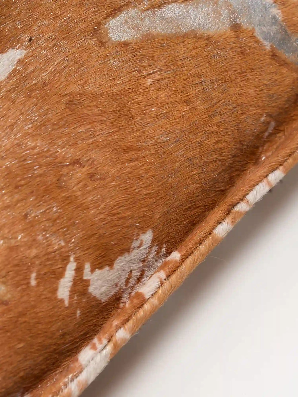 Close-up of Gilded Caramel hair-on surface and stitched bag edge