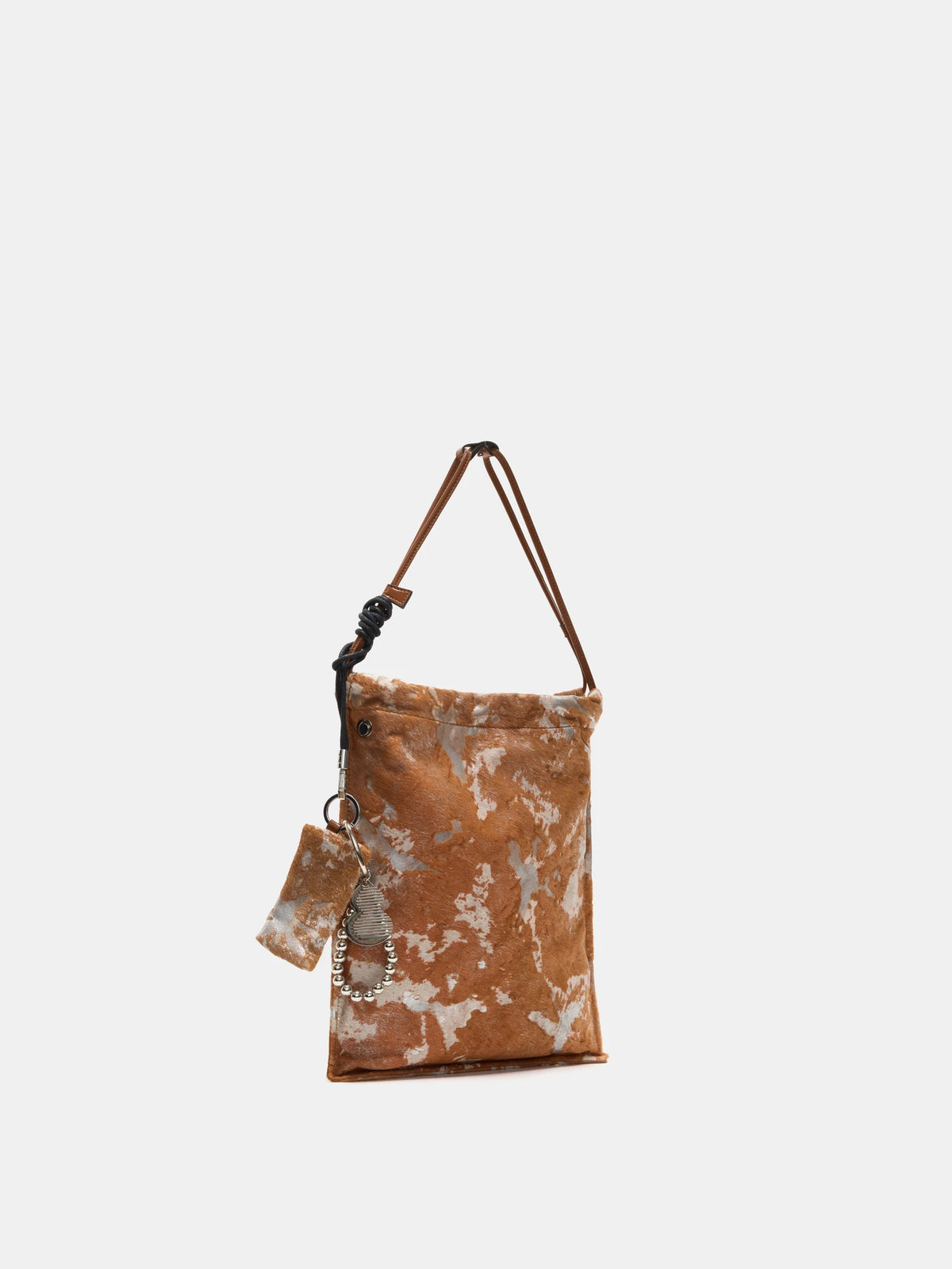 Angled view of Gilded Caramel bucket bag showing the tall silhouette and hanging accessories