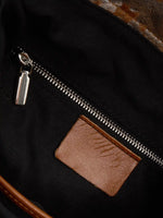 Black fabric lining and interior zip pocket of Gilded Caramel bucket bag