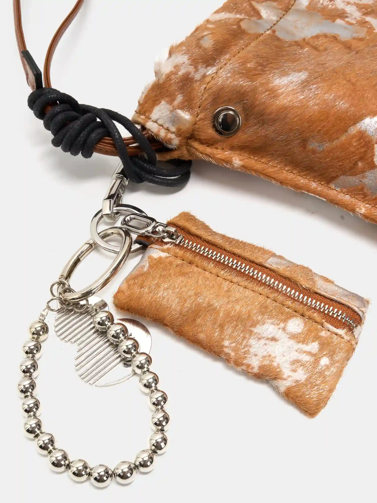 Black knotted cord, matching pouch, and silver-tone accessories on Gilded Caramel bag
