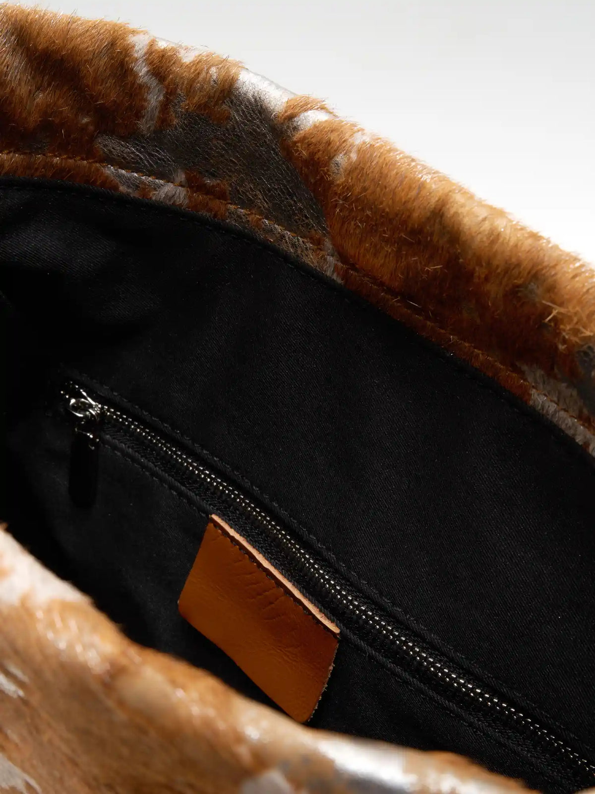 organized inside detail of The Painted Charm Slim Bucket Bag - Gilded Caramel
