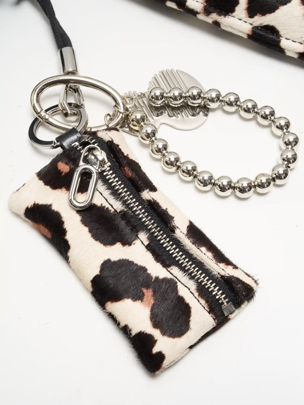 Leopard print zip pouch with silver-tone bead loop and sculptural metal accent